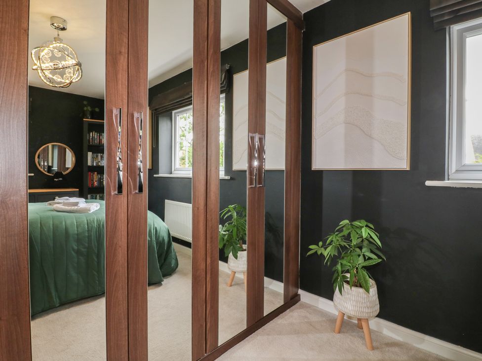 A bedroom featuring a bed, mirror, and plant at 7 Yarnfield Parkway