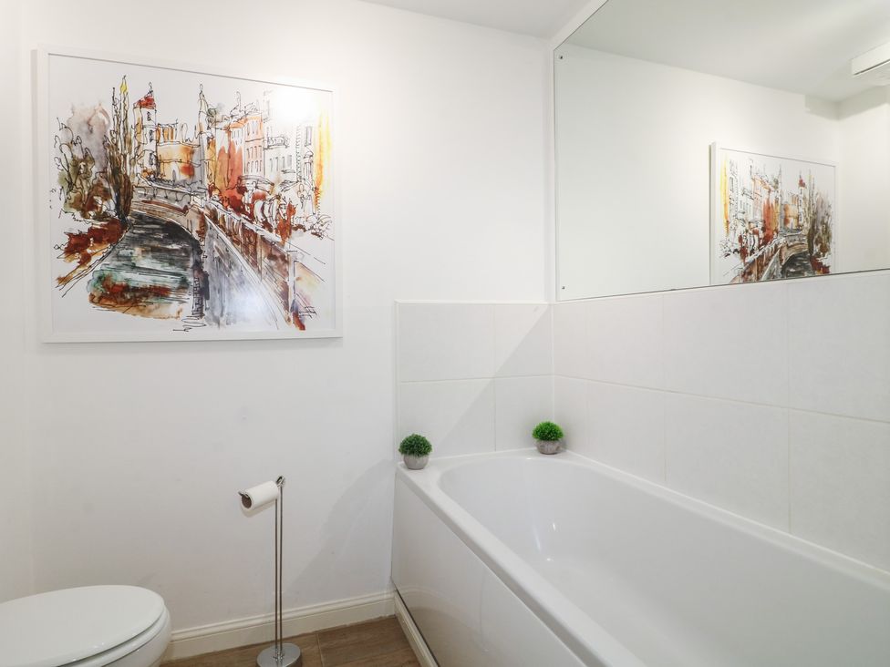 A bathroom with a bathtub and artwork at 7 Yarnfield Parkway