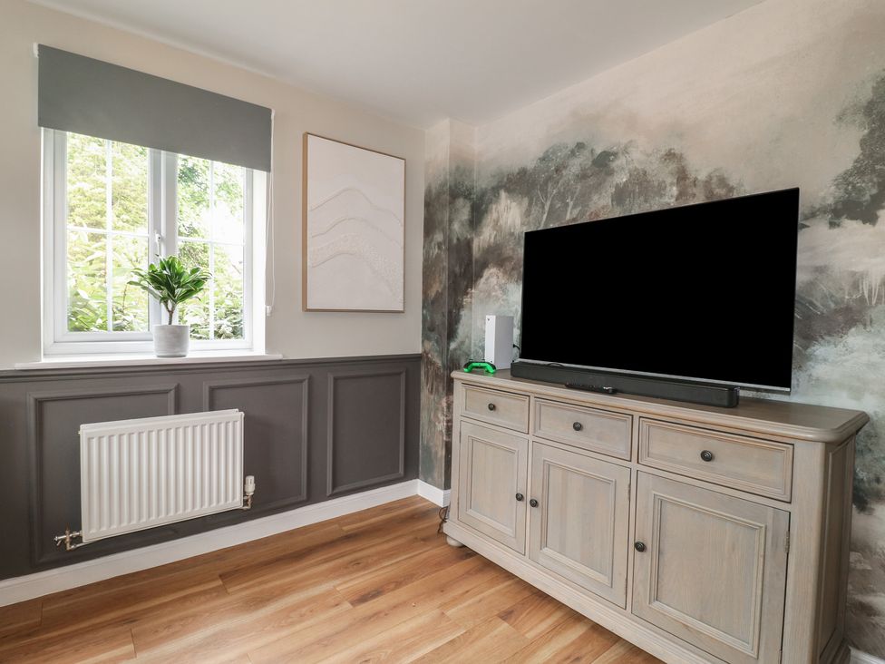 A living room with a TV and cabinet at 7 Yarnfield Parkway