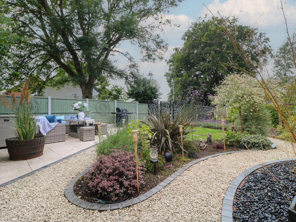 A garden with furniture, plants, and decorative stones at 7 Yarnfield Parkway