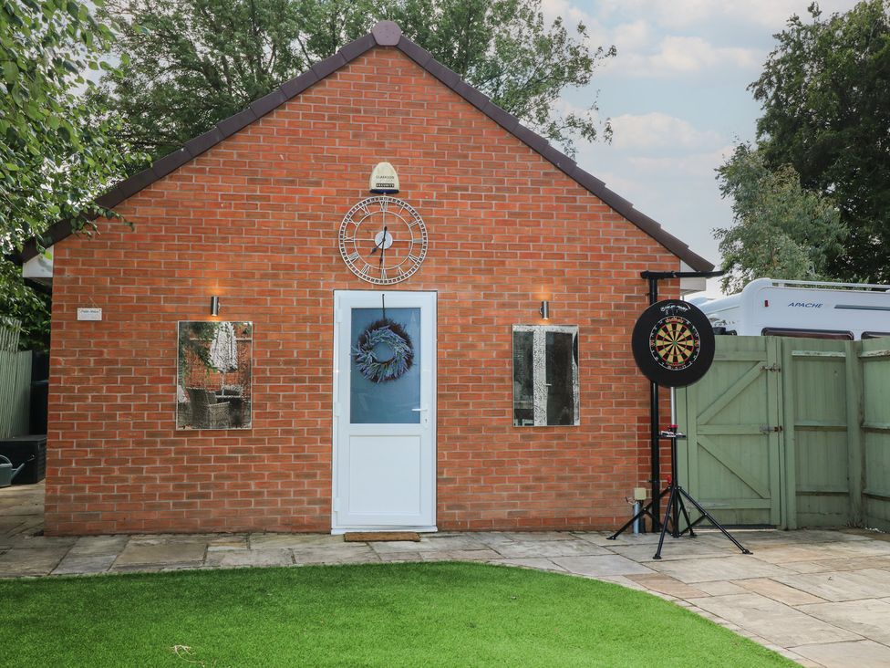 An exterior view of a brick building with a door and dartboard at 7 Yarnfield Parkway