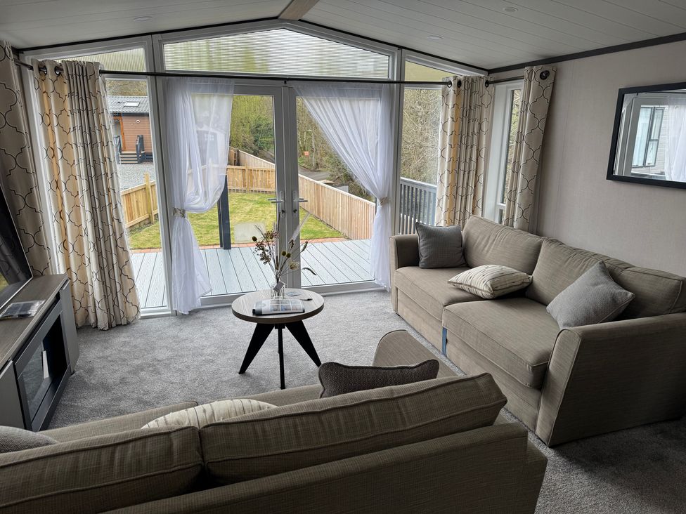 A living room with a sofa and sliding doors at Lime Tree Lodge