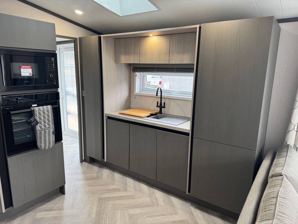A kitchen with cabinets and a sink at Lime Tree Lodge