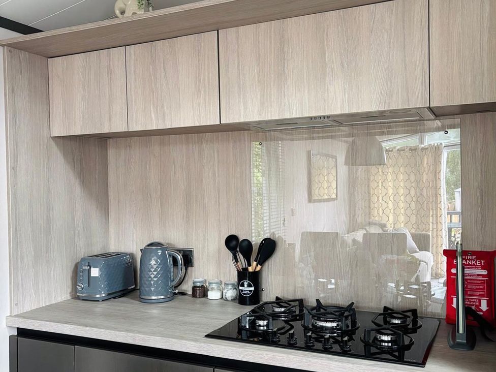 A kitchen with a gas stove and appliances at Lime Tree Lodge