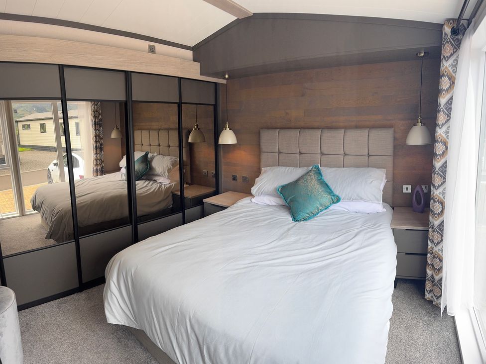 A bedroom with a bed and wardrobe at Lime Tree Lodge 