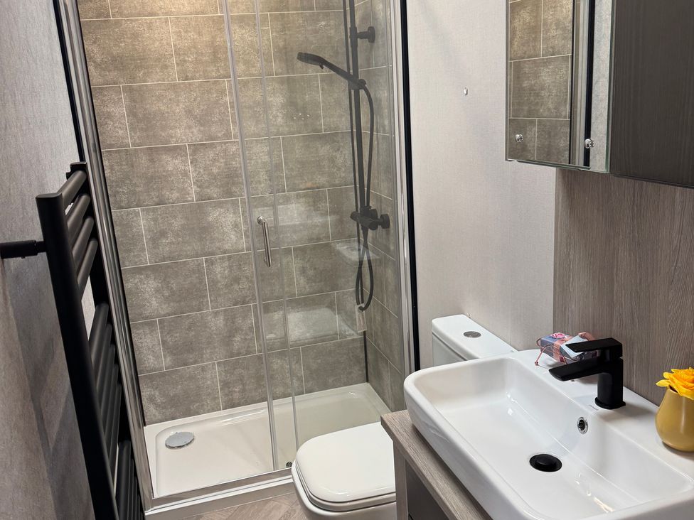 A bathroom with a shower, sink and toilet at Lime Tree Lodge