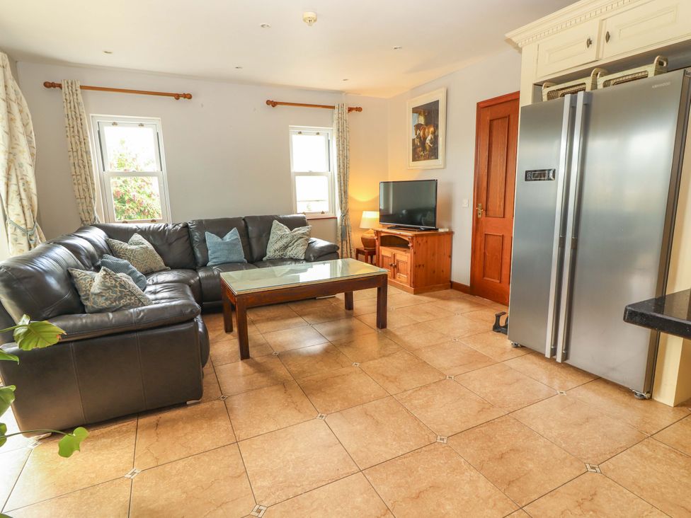 A living room with a sofa and television at Ash House in Ballyvaughan