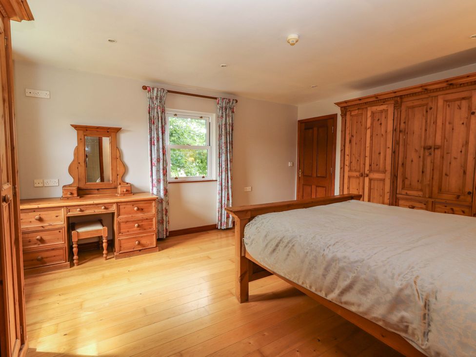 A bedroom with a bed and dressing table at Ash House in Ballyvaughan