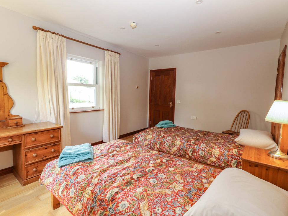 A bedroom with two beds and a dresser at Ash House in Ballyvaughan