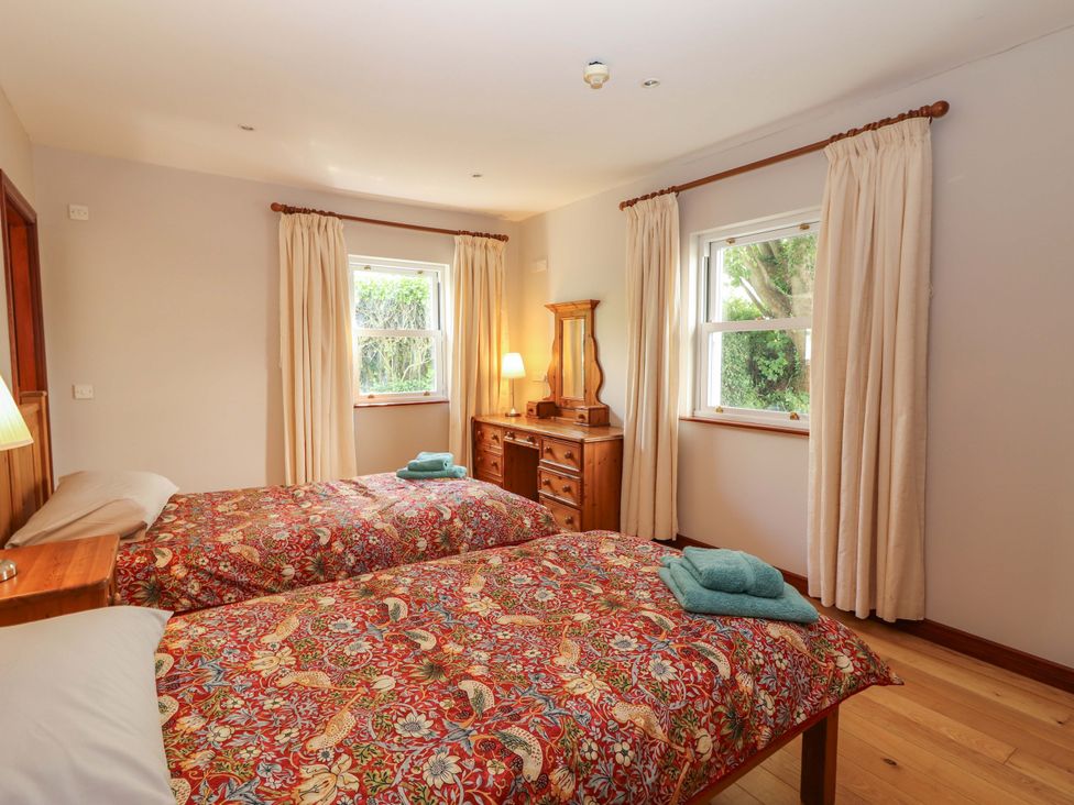 A bedroom with two beds and a dresser at Ash House in Ballyvaughan