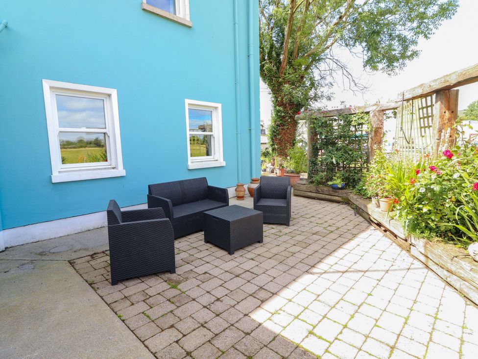 An outdoor seating area with chairs and a table at Ash House in Ballyvaughan