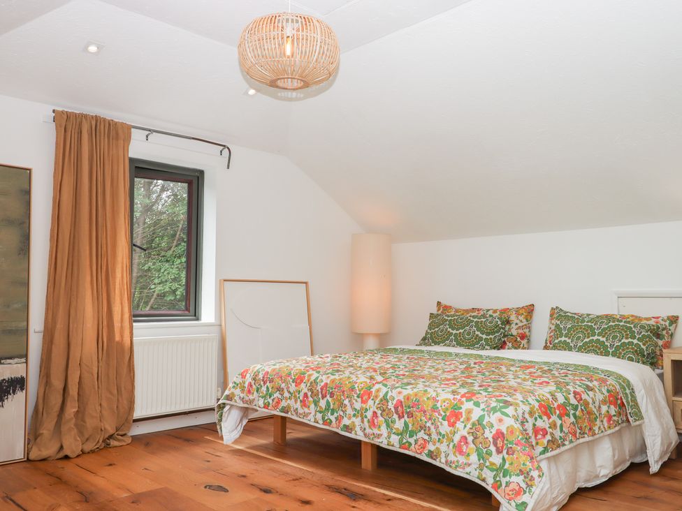 A bedroom with a bed and window at Tigley Meadow Coach House in Totnes