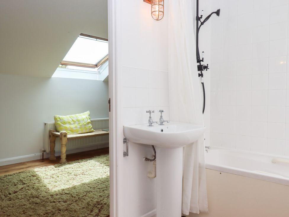 A bathroom with a wash basin and bathtub at Tigley Meadow Coach House in Totnes
