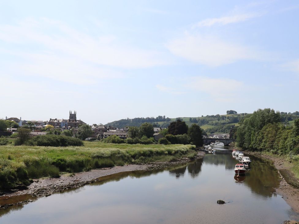 A river with boats and buildings near the water at Tigley Meadow Coach House in Totnes