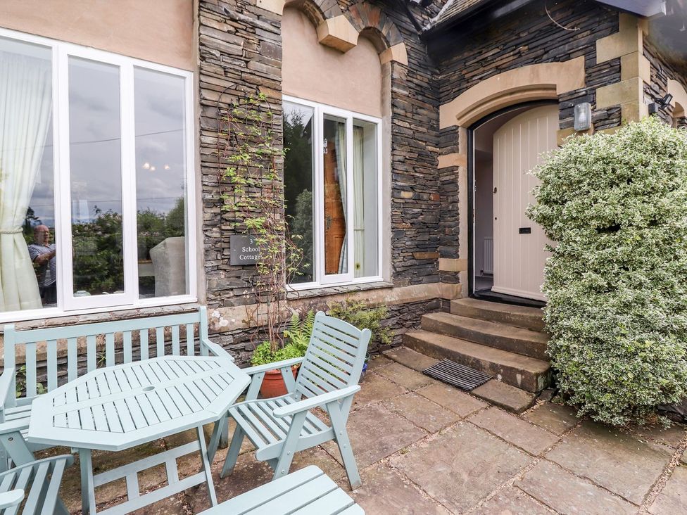 An entrance area with outdoor furniture and a tiled pathway at School Cottage in Windermere