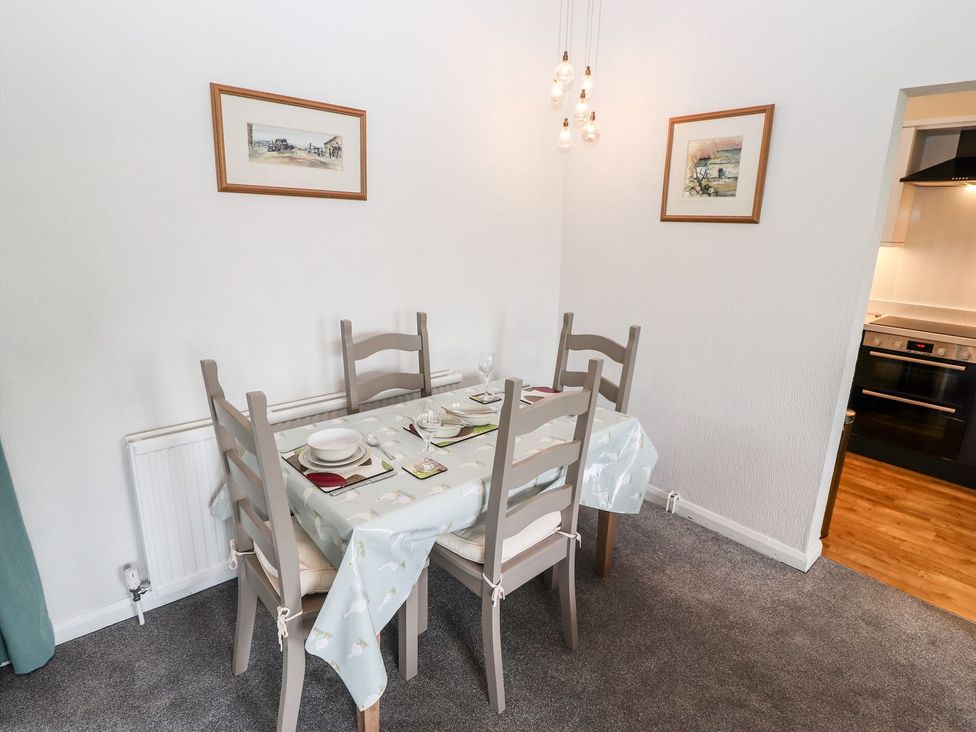A dining room with a table and chairs at School Cottage in Windermere