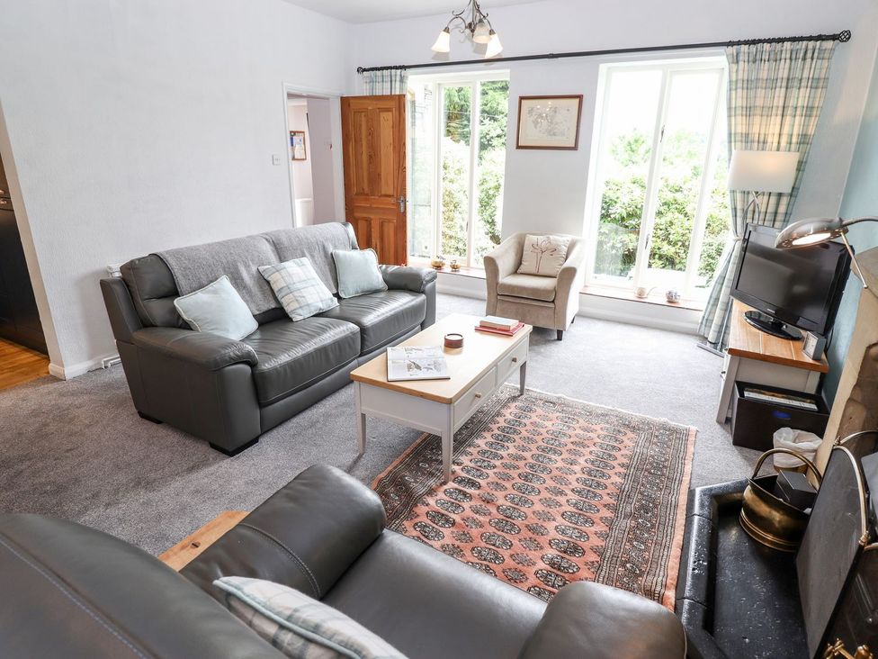 A living room with a sofa and television at School Cottage in Windermere