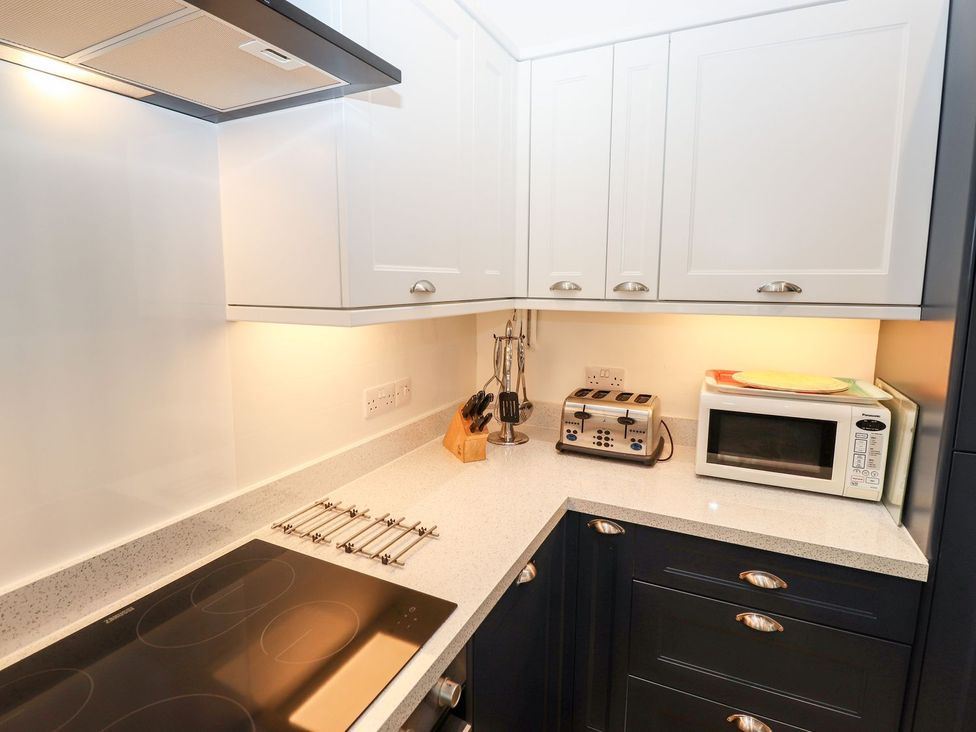 A kitchen with cabinets and appliances at School Cottage in Windermere