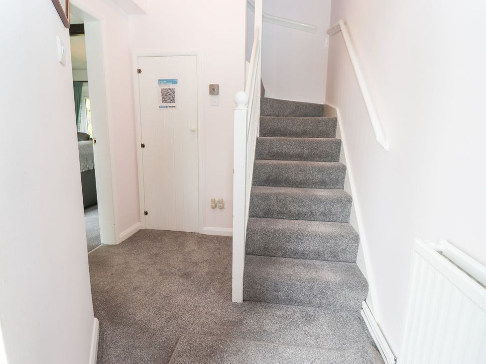 A hallway with a staircase and door at School Cottage in Windermere