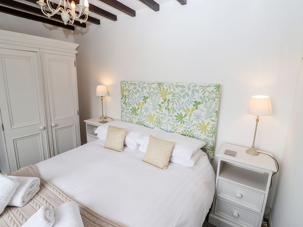 A bedroom with a bed and wardrobe at School Cottage in Windermere