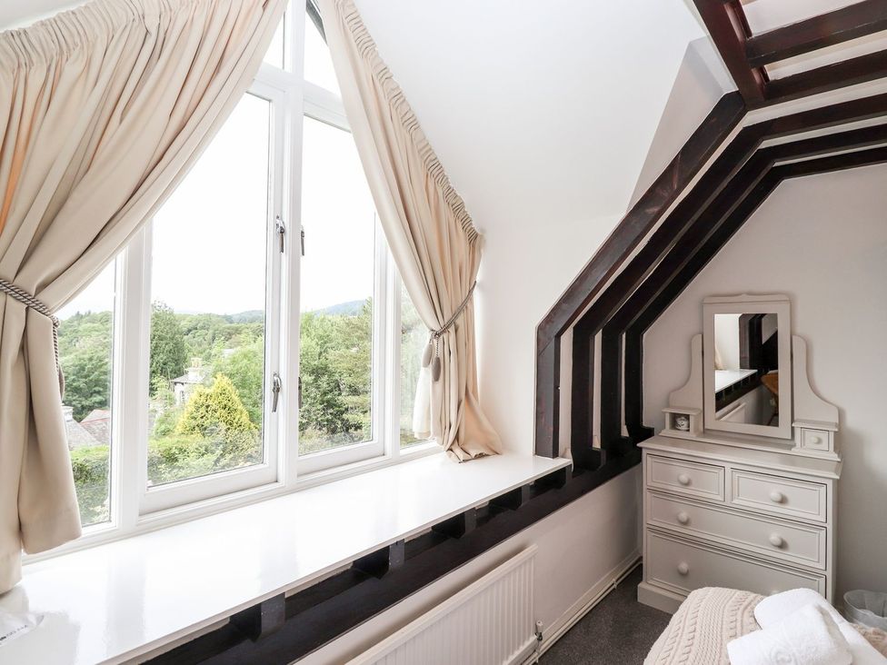 A bedroom with a window and dressing table at School Cottage in Windermere
