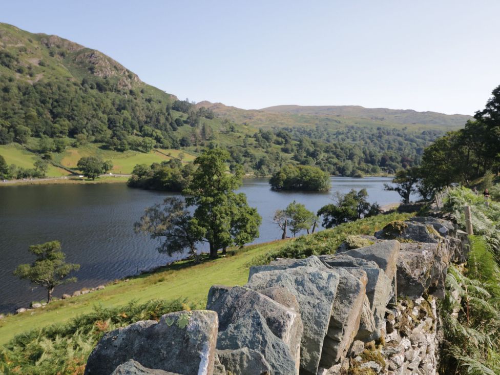 A view of a lake surrounded by trees and mountains at School Cottage in Troutbeck Bridge near Windermere