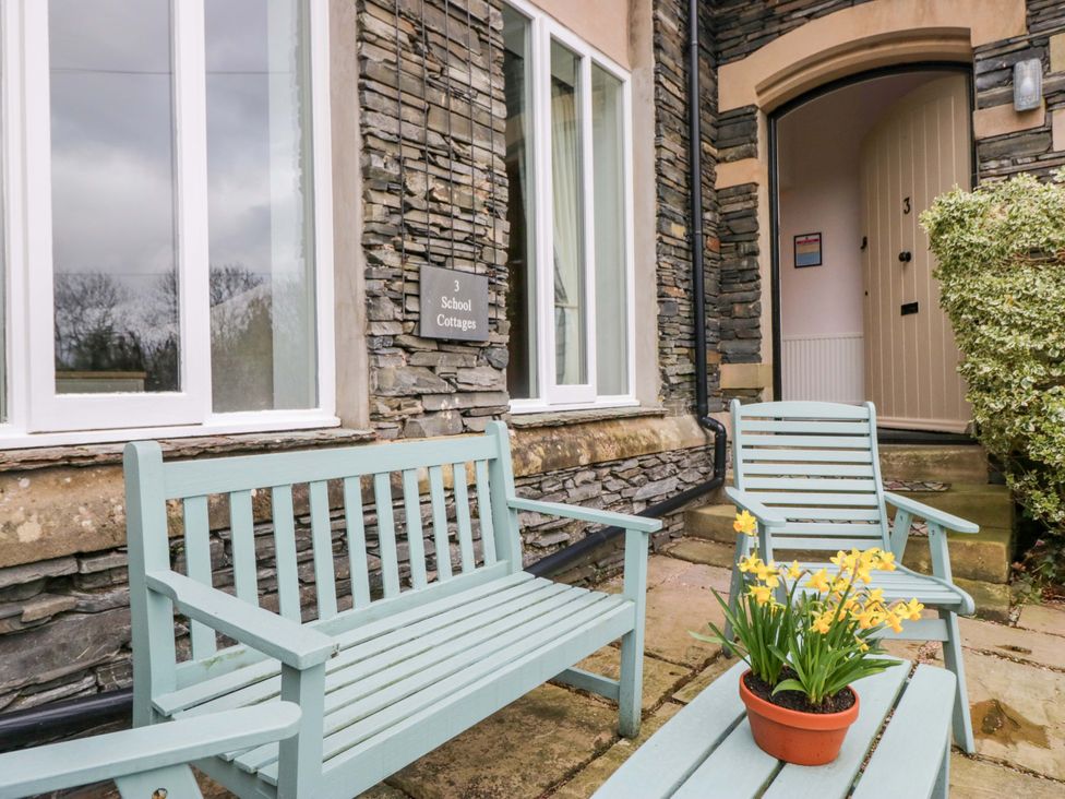 An outdoor area with benches and flowers at School Cottage in Troutbeck Bridge near Windermere