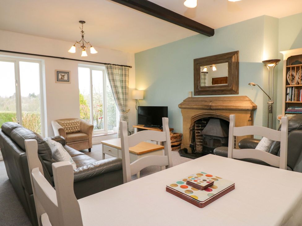 A living room with a fireplace and sofa at School Cottage Troutbeck Bridge near Windermere