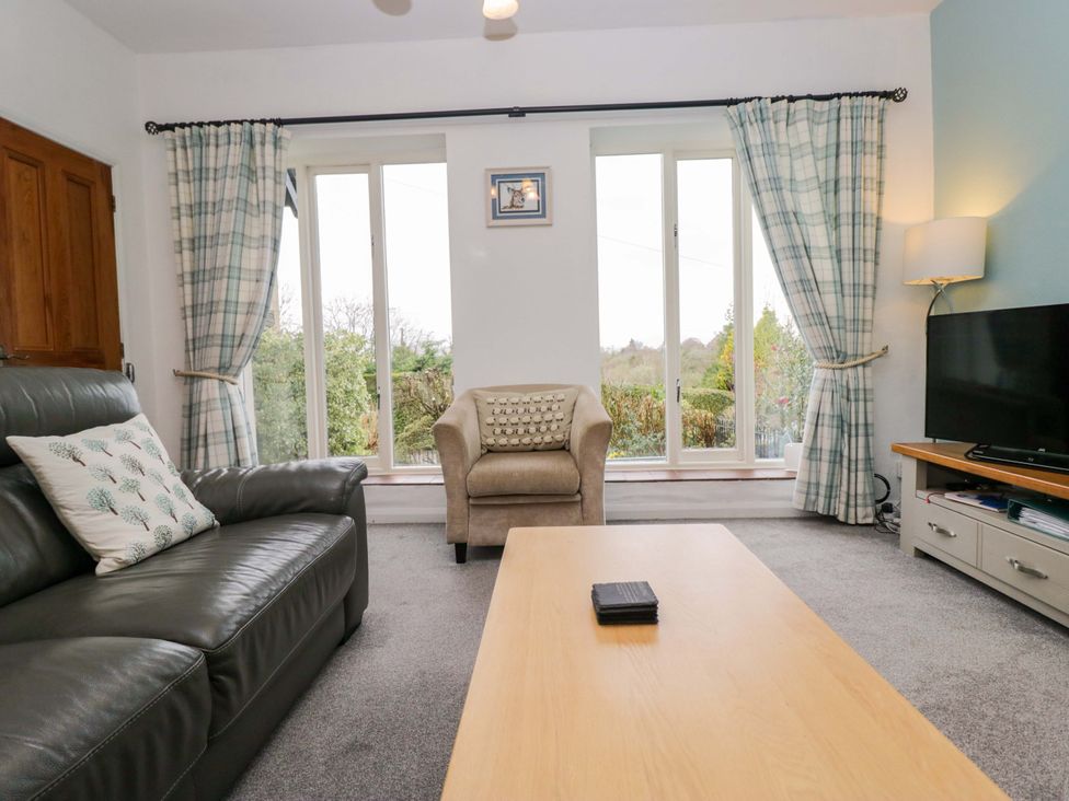 A living room with a sofa and a coffee table at School Cottage Troutbeck Bridge near Windermere
