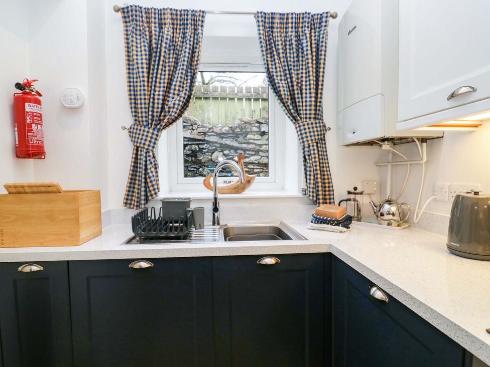 A kitchen with sink and window at School Cottage in Troutbeck Bridge near Windermere