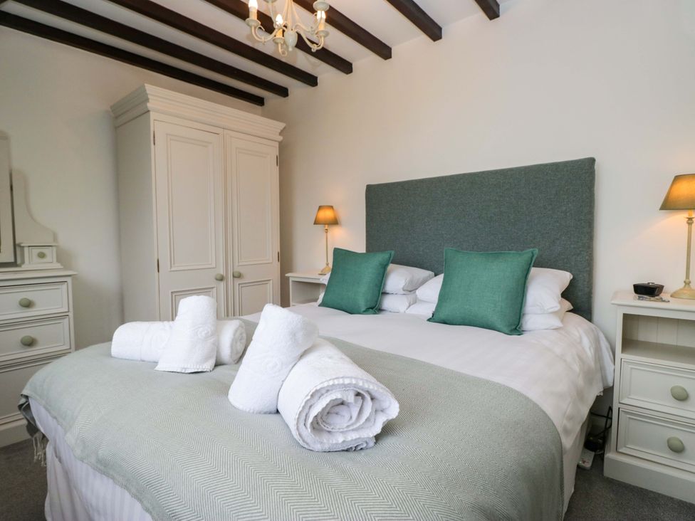A bedroom with a bed and wardrobe at School Cottage in Troutbeck Bridge near Windermere