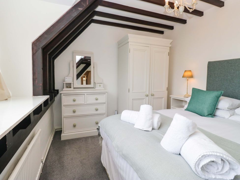 A bedroom with a bed and a dressing table at School Cottage Troutbeck Bridge near Windermere