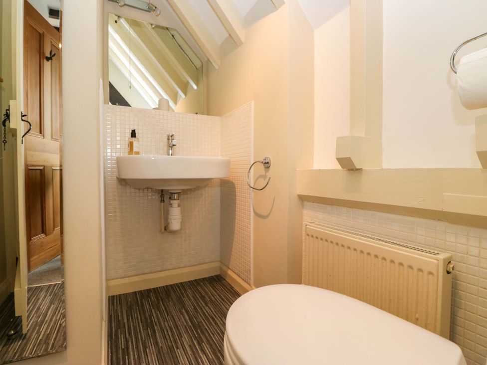 A bathroom with a sink, toilet and radiator at School Cottage in Troutbeck Bridge near Windermere