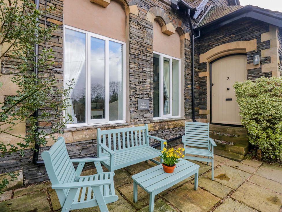 An outdoor area with seating and a door at School Cottage in Troutbeck Bridge near Windermere