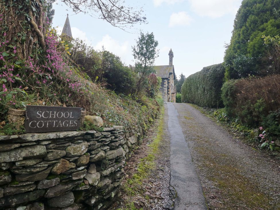 A sign for School Cottages along a pathway near the building at School Cottage in Troutbeck Bridge near Windermere