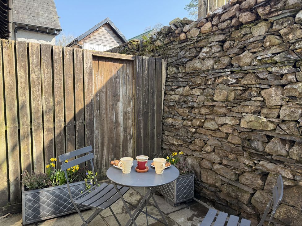 A garden area with a table and chairs at School Cottage near Troutbeck Bridge