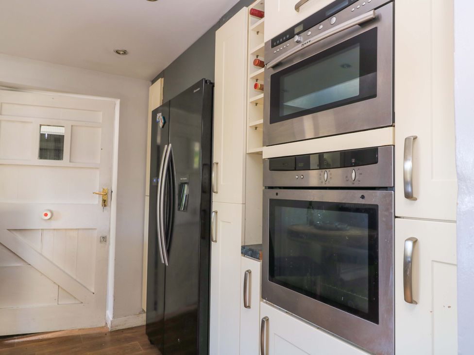 A kitchen with a fridge and ovens at The White House in Piddletrenthide