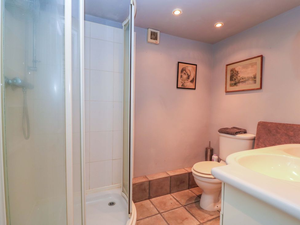 A bathroom with a shower, toilet, and sink at The White House in Piddletrenthide