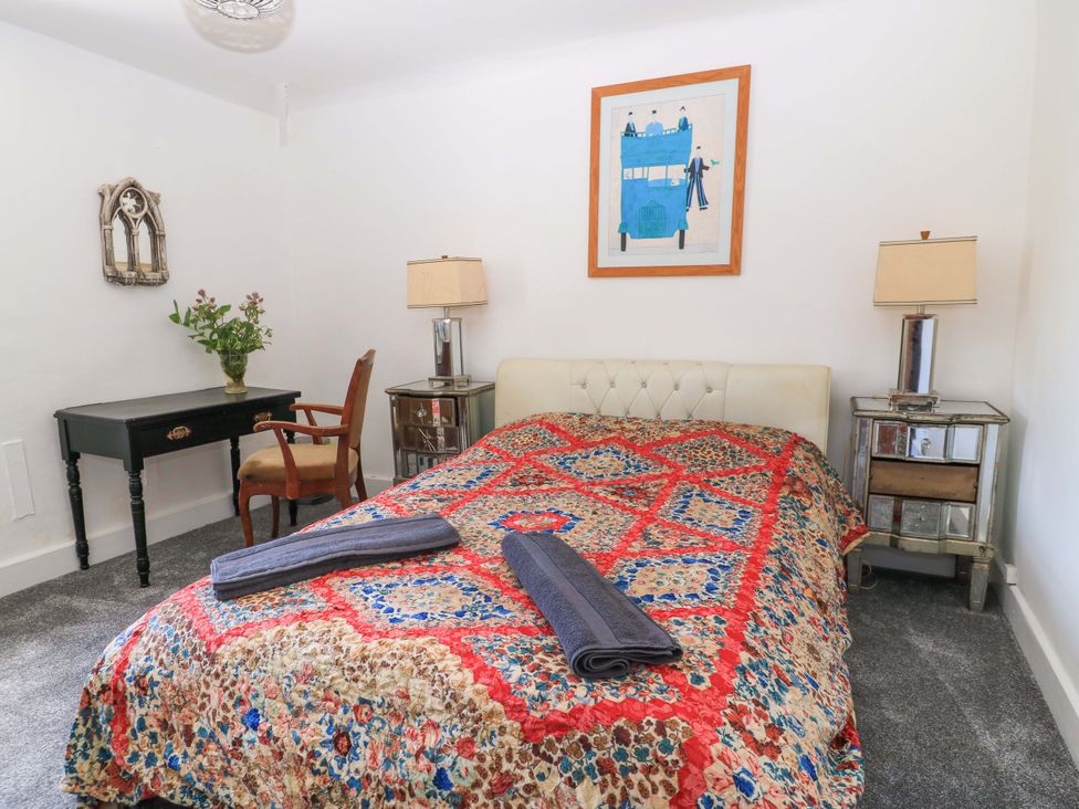 A bedroom with a bed, table, and lamps at The White House in Piddletrenthide
