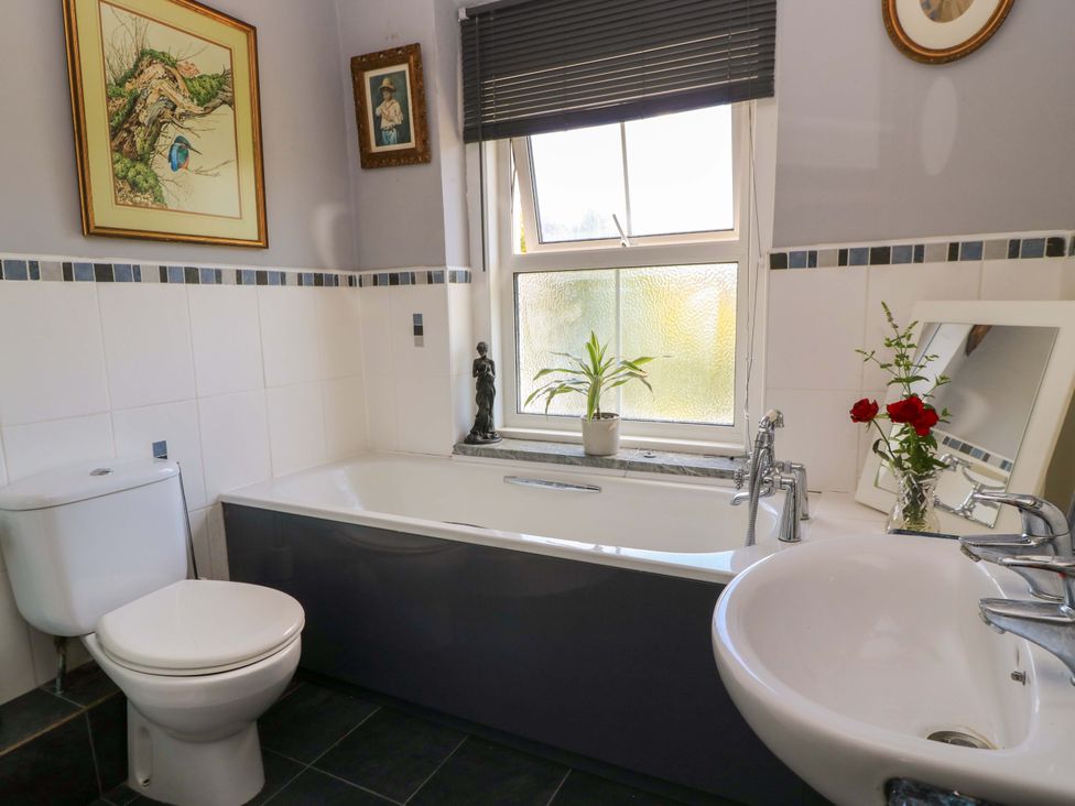 A bathroom with a bathtub, toilet, and sink at The White House in Piddletrenthide