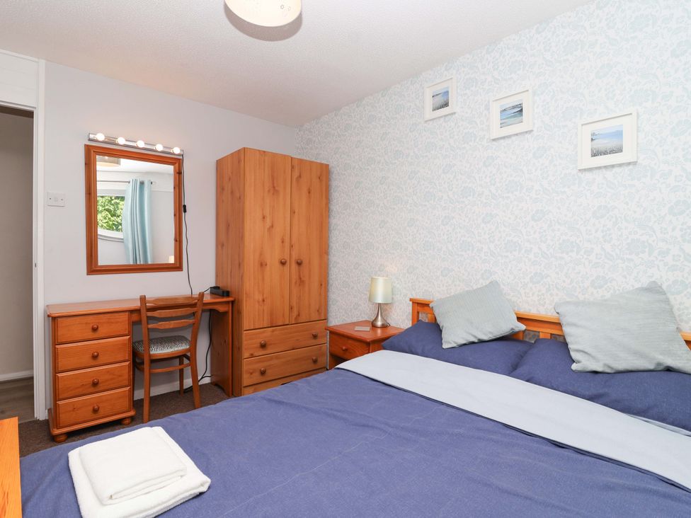 A bedroom with a bed and a desk at Boo’s Bungalow in Callington near Gunnislake