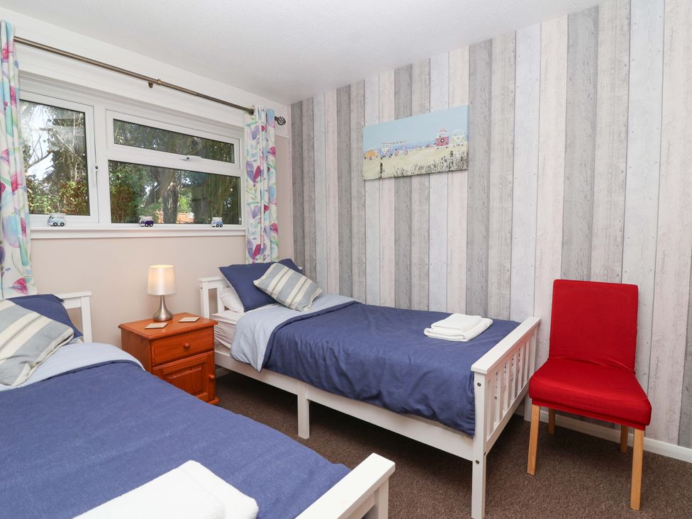 A bedroom with two beds and a nightstand at Boo’s Bungalow in Callington near Gunnislake