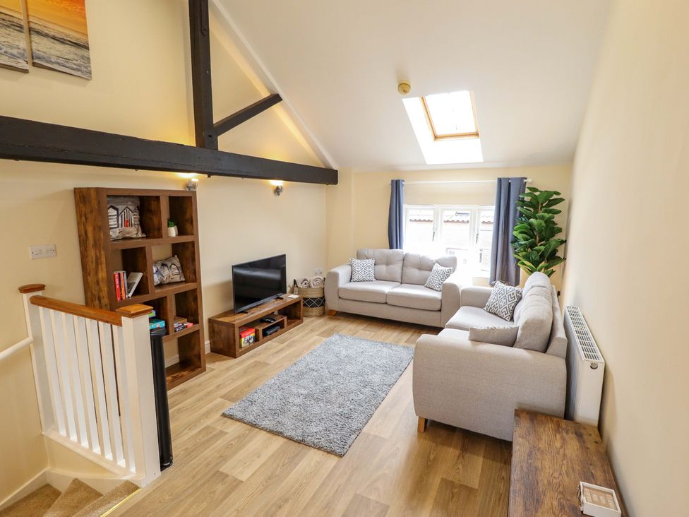 A living room with a television and seating at 3 The Old Drill Hall in Alford