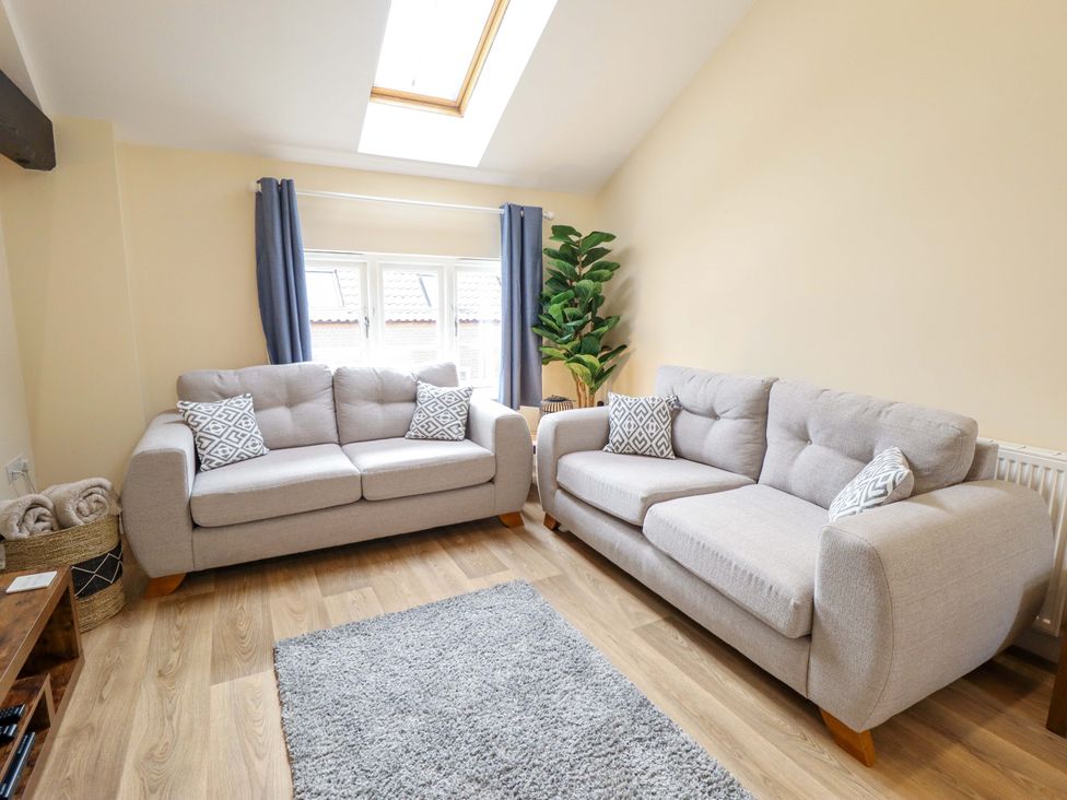A living room with sofas and a houseplant at 3 The Old Drill Hall Alford