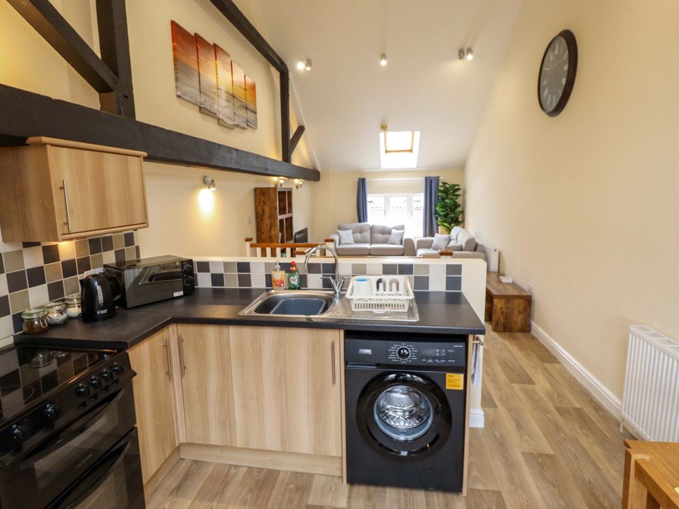 A kitchen with appliances and seating area at 3 The Old Drill Hall Alford