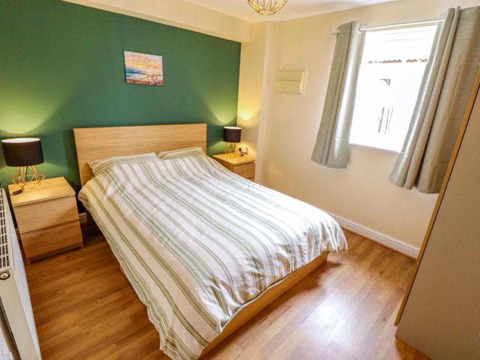 A bedroom with a bed and nightstands at 3 The Old Drill Hall in Alford