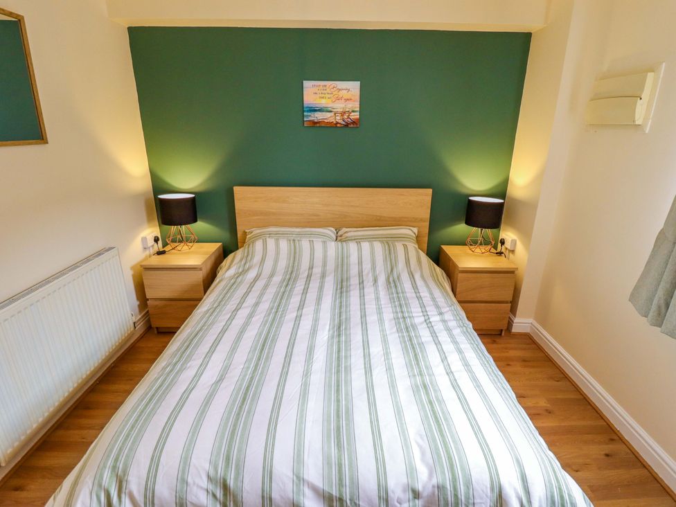 A bedroom with a bed and nightstands at 3 The Old Drill Hall in Alford