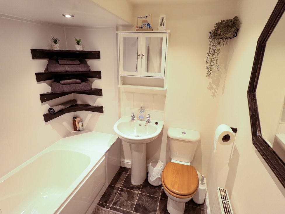A bathroom with a bathtub, sink, and toilet at 3 The Old Drill Hall Alford