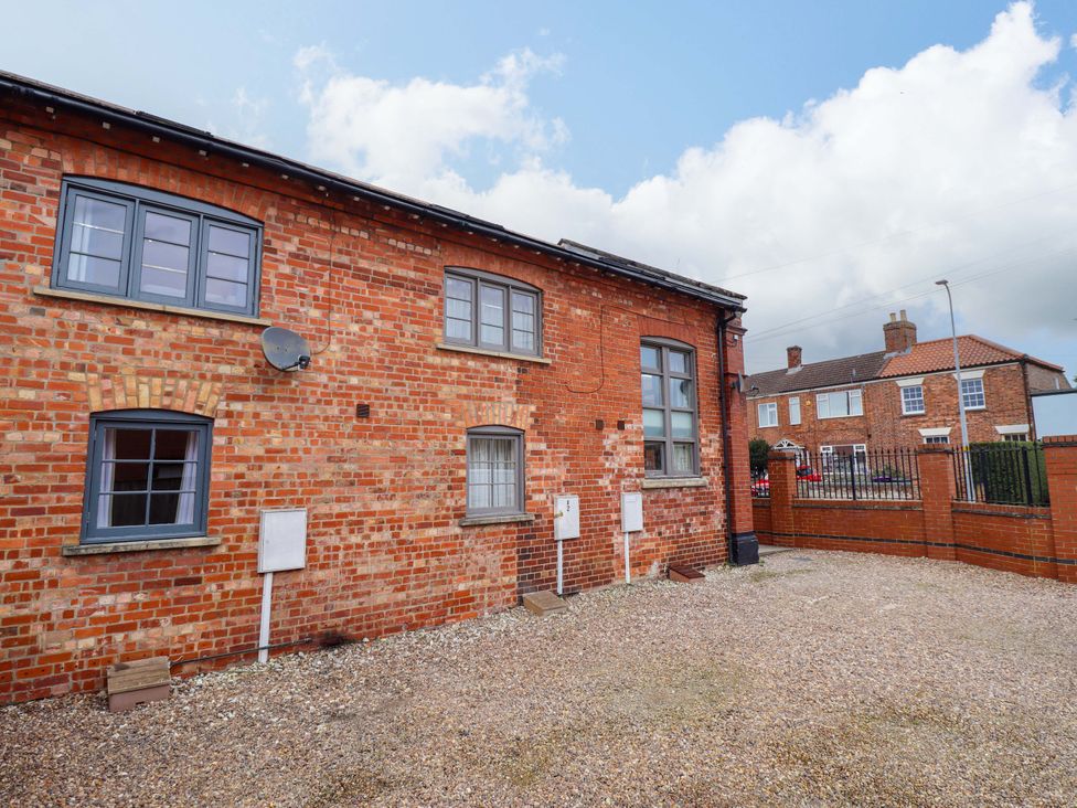An outdoor area with a brick wall and gravel at 3 The Old Drill Hall Alford