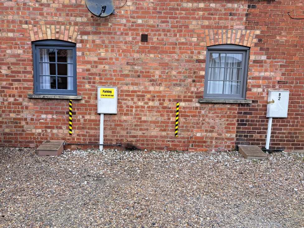 An outdoor area with a parking sign and two windows at 3 The Old Drill Hall Alford